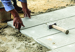 Man setting stones into places to create a walk way.